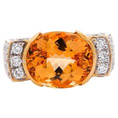 GIA certified vintage geometric Natural Orange Topaz and Diamond Ring, set in 18K Yellow Gold. This lovely cocktail ring boasts a brilliant oval-cut orange topaz center stone in half bezel setting, and round-cut diamond side stones. This ring is made with 18K yellow gold, and presented with a squared geometric shape. The center stone bears a rich, canary orange color hue with excellent luster and transparency. Item Details: - Type: Cocktail Ring - Metal: 18K Yellow Gold - Weight: 19.05 Grams - Ring Size: 8 (adjustable) - Setting: Half Bezel, Prong ___________________________________ Center Stone Details: - Type: Topaz - Carat: 7.30 (approx.) - Cut: Oval (Modified Brilliant) - Color: Orange-Yellow - Transparency: Transparent - Measurements: 13.13 x 11.02 x 7.45 mm GIA Certificate #: 5234030 Topaz And Diamond Ring, Half Bezel Setting, Cut Orange, Half Bezel, Diamond Ring Set, Ring Metal, Bezel Diamond, Vintage Ring, Square Shape