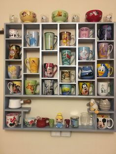 a shelf filled with cups and mugs on top of each other next to a wall