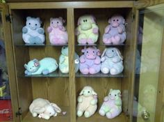 a wooden cabinet filled with lots of stuffed animals