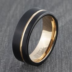 a black and gold wedding ring with two tone inlays on the outside of it