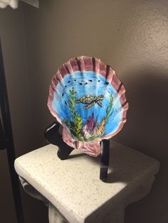 a paper plate with an image of a turtle on it is sitting on a pedestal