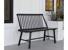 a black bench sitting in front of a white building