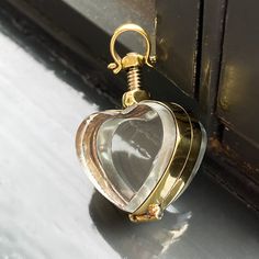 Gold Locket Necklace (mini size) Our mini gold lockets are the best way to store life's little treasures and wear them around your neck for eternity.  So easy to open and double-sided to contain two special photographs or a cherished memory item that can be viewed from both sides.  The lockets have a 5mm internal gap so you can even store crystals inside or some pills (daily medication if you are going on a trip, perhaps?). This beautiful Victorian style hand-crafted locket pendant holds a small memorial or keepsake for your loved one to cherish.  This is the perfect memorial gift to store the ashes of a late pet dog or cat, or maybe even some of their fur inside. To open and close the locket, simply screw or unscrew the silver nut.  All lockets in this section are approximately 1.5 inches Gold Charms Locket Necklace Keepsake, Brass Locket Necklace With Charms For Keepsake, Gold Locket Necklace With Lobster Clasp As Gift, Gold Locket Necklace With Charms For Memorial, Gold Heart Locket Necklace Spiritual Style, Gold Locket Necklace For Keepsake, Gold Heart-shaped Spiritual Locket Necklace, Nickel Free Gold Pendant Locket Necklace, Nickel-free Gold Pendant Locket Necklace