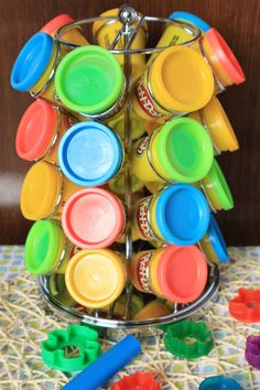 a metal container filled with lots of colorful plastic cups and saucers on top of a table