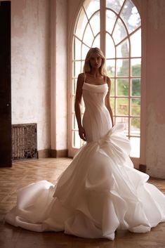 a woman in a wedding dress posing for the camera