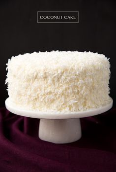 a coconut cake with white frosting on a plate