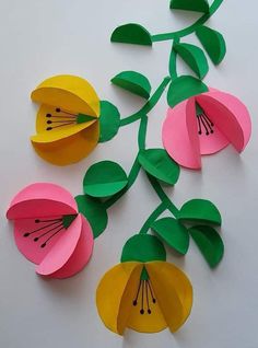 paper flowers with green leaves and yellow petals on white background, cut out from different colors