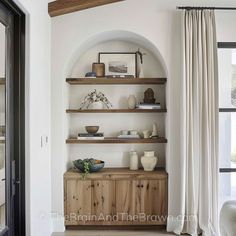 a living room with white walls and wooden shelves