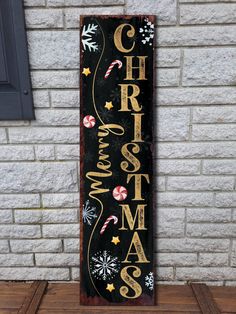 a wooden sign that says christmas with candy canes and snowflakes on it