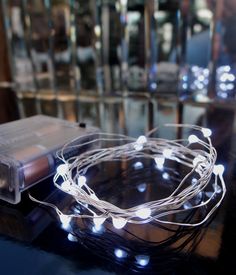 an electronic device is sitting on a table with some string lights in front of it