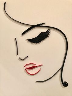 a woman's face with black hair and red lips