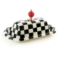 a black and white checkered tray with a red apple on it's top