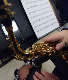 a person is playing the saxophone in front of sheet music