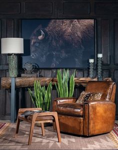 a living room filled with furniture and a large bison painting on the wall behind it