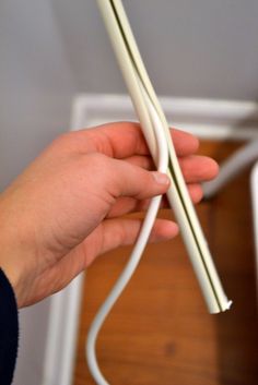 a person is holding two white wires in their hand