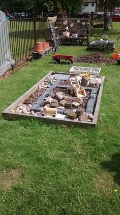 an outdoor fire pit in the middle of a yard with lots of rocks on it