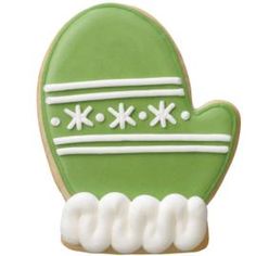 a green cookie with white frosting on it's face and the shape of a mitt