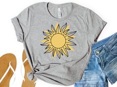 Sun t-shirt, sun worshipper, boho, sun lover t-shirt, here comes the sun This classic unisex jersey short sleeve tee fits like a well loved favorite that makes the best gift for any event. Chose from the various sizes and colors. T-Shirts ----------- *Bella Canvas *Solid Colors: 100% cotton *Heather Colors: 52% cotton, 48% polyester *crew neck *unisex sizing *all t-shirts are very soft CARE -------- *wash inside out in cold water *tumble dry low or air dry *do not bleach *Do not iron directly on the design *do not dry clean PRODUCTION TIME --------- *orders are processed within 2-5 business days before being shipped out. During the holidays, please expect delays due to the volume is higher than normal. RETURNS/EXCHANGES -------- Our shirts are made as each order comes in. They vary on colo Summer Casual T-shirt With Sunflower Print, Graphic Print Festival T-shirt For Summer, Summer Festival Graphic Print T-shirt, Summer Bohemian T-shirt For Vacation, Bohemian Summer T-shirt For Vacation, Summer Vacation Bohemian T-shirt, Bohemian Summer Vacation T-shirt, Summer Crew Neck Top, Bohemian Yellow T-shirt For Summer