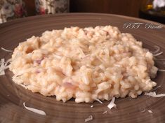 a brown plate topped with rice on top of a wooden table next to a bottle