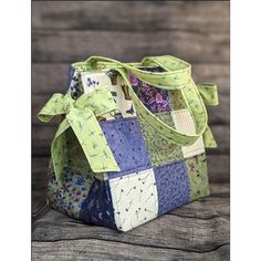 a multicolored patchwork purse sitting on top of a wooden table