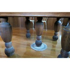 an image of a dining room table with vases on the floor and chairs around it