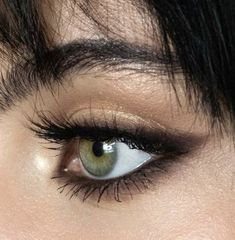 an eye with long black hair and green eyeshade