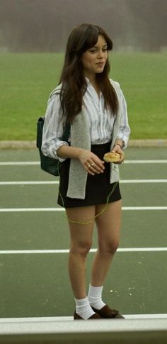 a woman standing on top of a tennis court holding a racquet in her hand