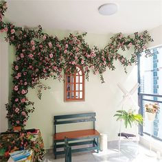 a bench sitting in front of a window with pink flowers on it