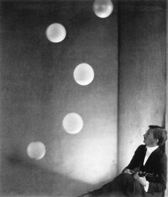 black and white photograph of a woman sitting on the ground with circles in the background