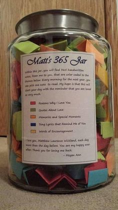 a glass jar filled with lots of colorful paper notes on top of a counter next to a wooden door