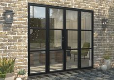 a brick building with glass doors and potted plants