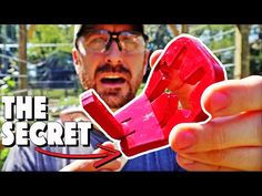 a man holding a red object with the words the secret in front of his face