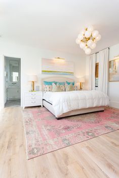 a white bed sitting in a bedroom on top of a hard wood floored floor