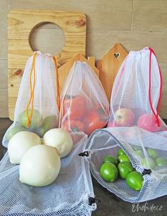 three mesh bags filled with different types of fruits and vegetables sitting on top of a table