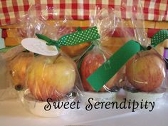 three apples wrapped in cellophane and sitting next to each other on a table