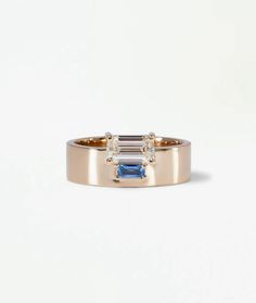 a gold ring with two blue and white stones on the side, set in 18k yellow gold