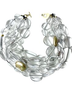 Medium-size glass-like irregular clear and gold beads are in a multistrand design for day or night.  The medium-sized beads resemble icicles with accent gold beads breaking the clear pattern. The necklace measures 21 IN/23 OZ. Clear Faceted Beads Jewelry For Party, Clear Jewelry With Faceted Beads For Party, Clear Glass Jewelry With Faceted Beads, Clear Lucite Party Jewelry, Modern Gold Glass Necklace, Multi-strand Glass Necklaces For Party, Elegant Multi-strand Glass Beaded Necklaces, Formal Gold Lucite Jewelry, Elegant Single Strand Clear Necklace