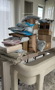 a pile of boxes sitting on top of a table next to a bench in front of a window