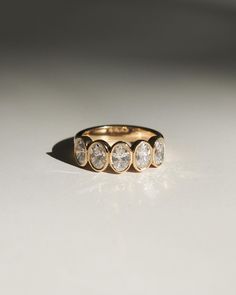 a gold ring with five diamonds on it