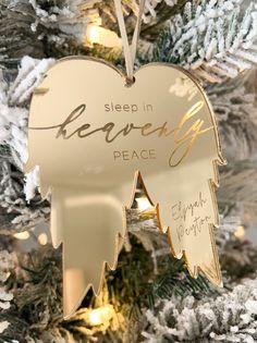 an angel ornament hanging from a christmas tree with the words sleep in heaven