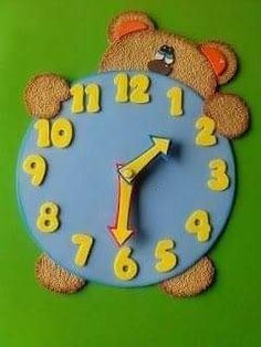 a blue clock with yellow numbers and a brown teddy bear on it's face