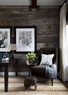 a living room with wood paneling and two pictures on the wall, one is black and white