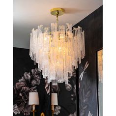 a chandelier hanging from the ceiling in a room with black and white wallpaper