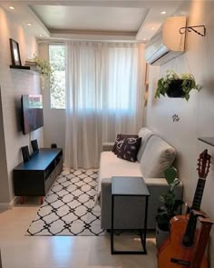 a living room filled with furniture and a flat screen tv mounted to the wall next to a window