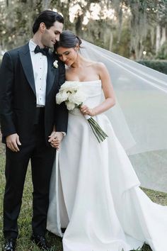 a bride and groom pose for a photo in front of the veil on their wedding day