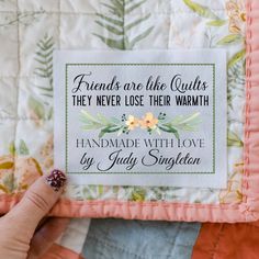 someone is holding up a quilt that says friends are the quiets they never lose their warmth