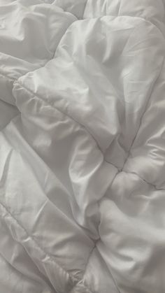 an unmade bed with white sheets and pillows