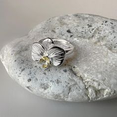 This Orchid ring in 925 sterling silver with gold plating is a true work of art that combines natural beauty and elegance. Designed in the shape of a delicate orchid, this adjustable ring fits any finger size, ensuring comfortable wear and a flawless look. The gold plating adds a warm, luxurious touch to the ring, emphasizing the delicate details of the floral design. Ring: material - silver, gold plating  size - adjustable  UK 16 - 18 EU 50,54 - 56,92 US 5,5 - 8 This ring will be the perfect gi Yellow Open Ring Promise Ring, Yellow Open Ring For Promise, Gold Sterling Silver Flower Ring For Promise, Yellow Flower Ring For Anniversary, Yellow Open Promise Ring, Hallmarked Open Flower Ring For Promise, White Gold Flower Ring With Polished Finish As Gift, Yellow Flower Wedding Rings, Gold Sterling Silver Flower Ring