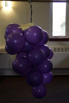 a bunch of purple balloons hanging from a ceiling