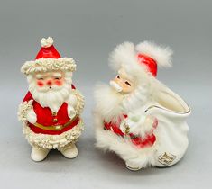 two santa claus figurines sitting next to each other